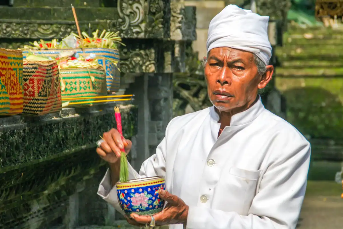 Priester zegent offers bij Tirta Empul Tampaksiring